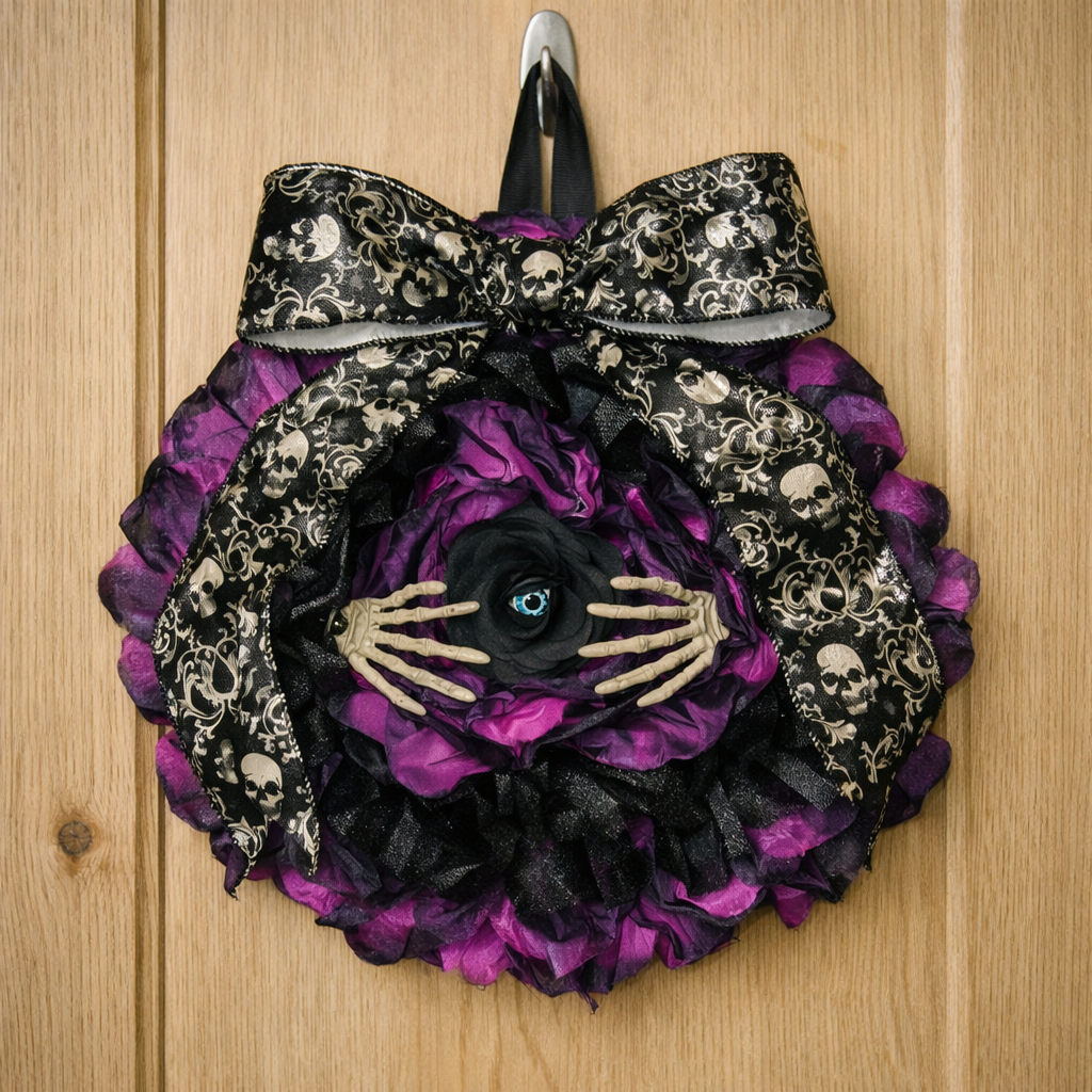 Purple and black circular striped wreath with an eye at the middle and two skeleton hands spreading the flower to see out and a lovely victorian bow at the top